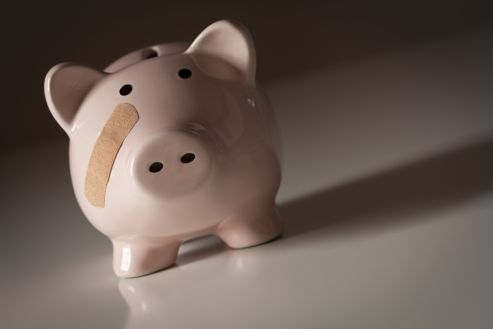 Piggy bank with a bandaid on its face