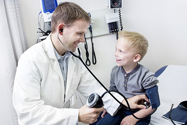 Male pediatrician examining a little boy
