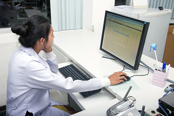 Female medical professional working on desktop computer