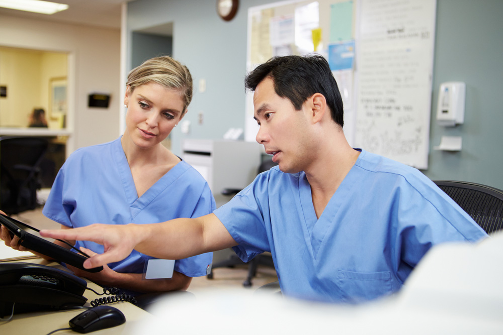 Medical professionals looking at a digital tablet together