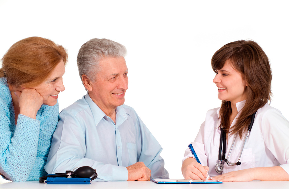 Medical professional smiling and speaking with a patient and family