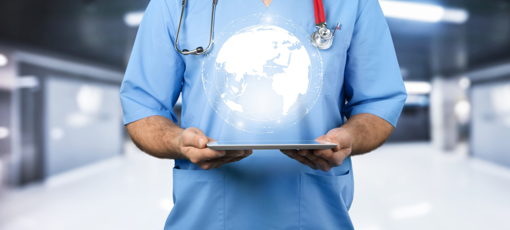 Medical professional holding a digital tablet with an icon of the globe hovering above the screen