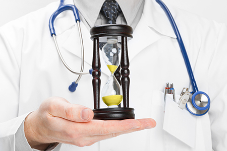 Doctor holding in his hand a hourglass