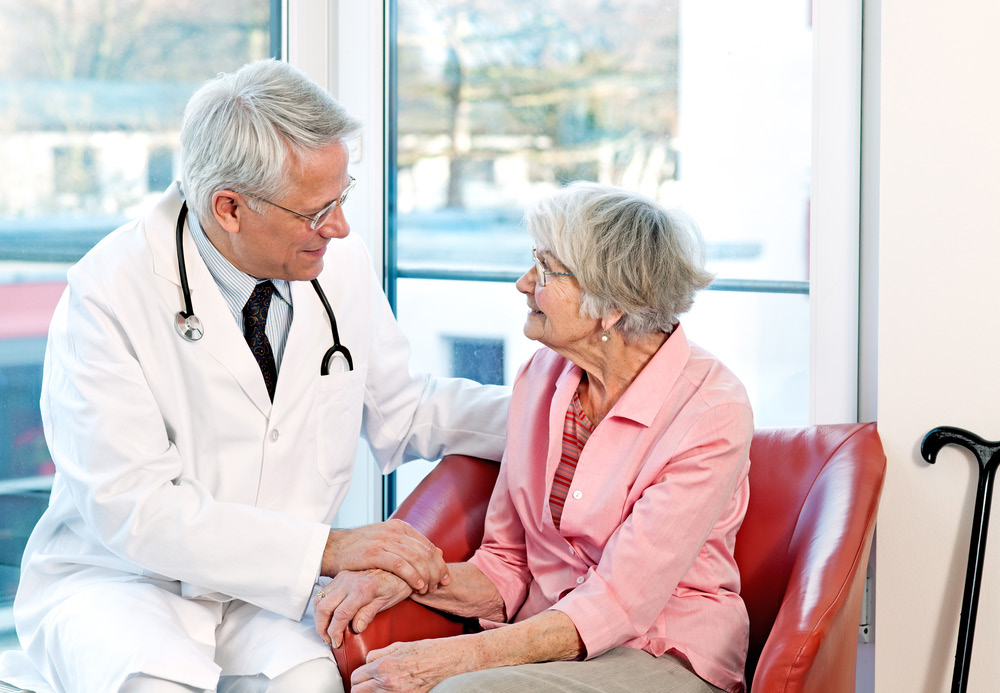 Male doctor comforting elderly woman