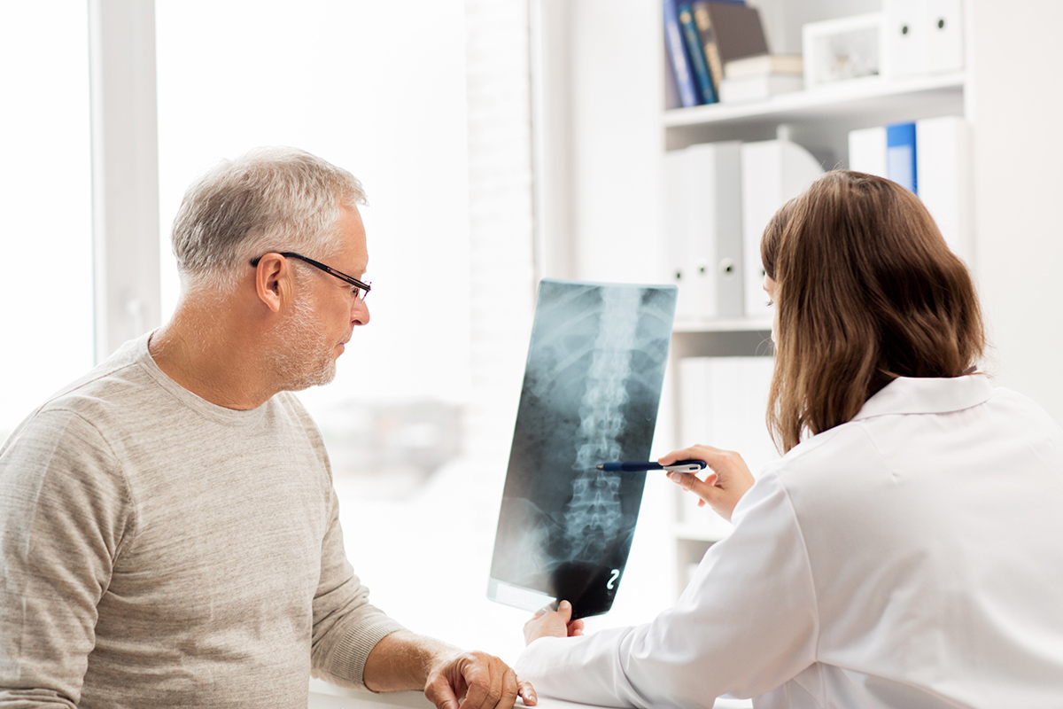 doctor and patient looking at a spine x-ray