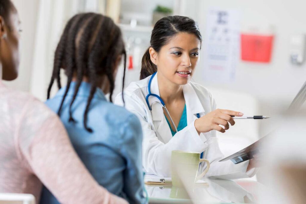 female doctor reading chart to patient